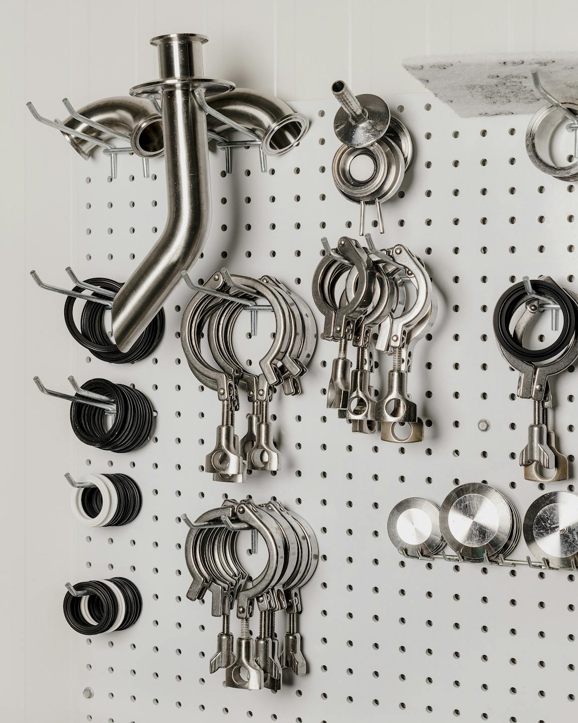 A pegboard filled with shiny metal tools.